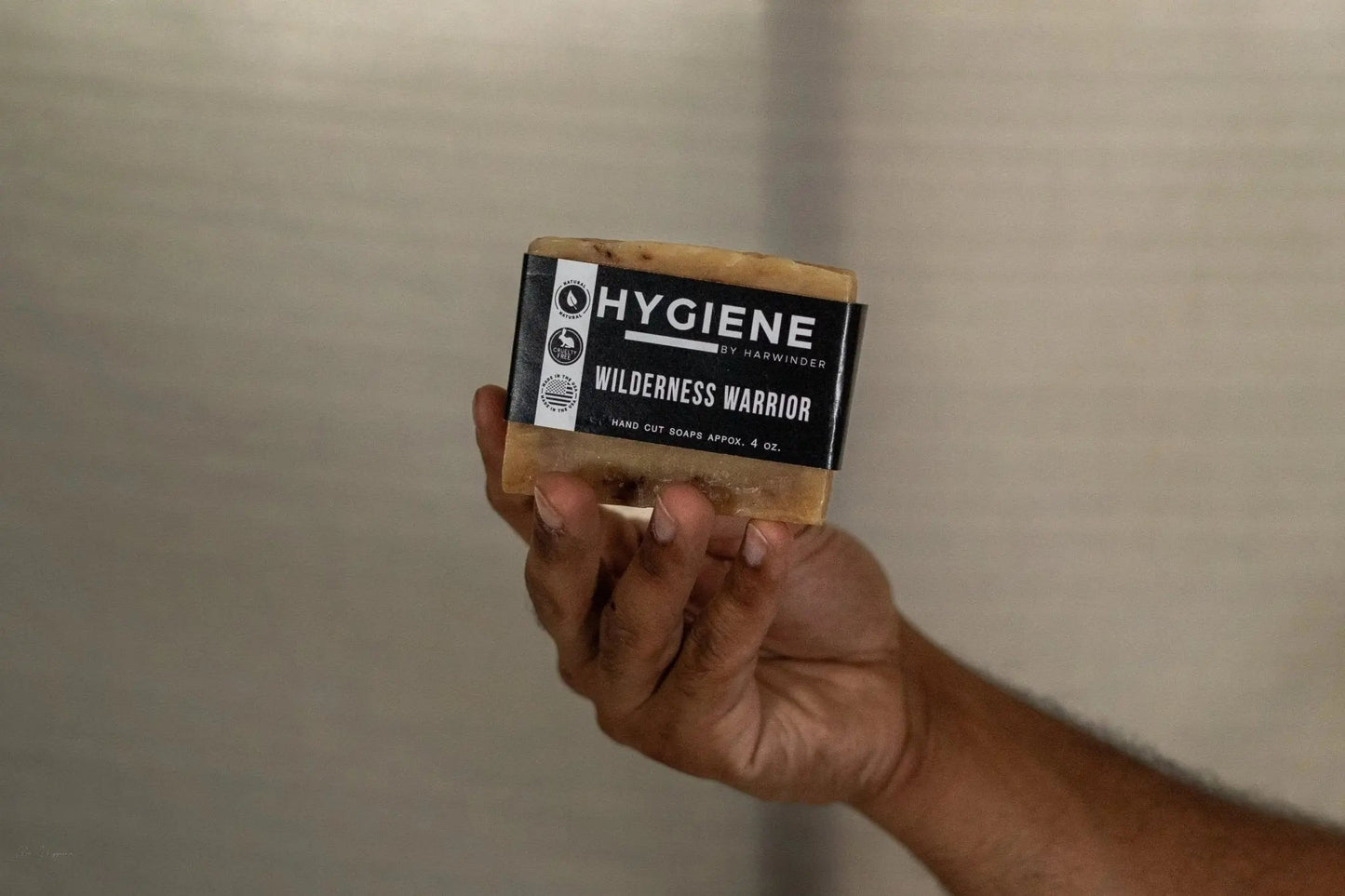 Hand holding Wilderness Warrior Bar Soap for men, emphasizing natural grooming and earthy scent, perfect for outdoor enthusiasts.