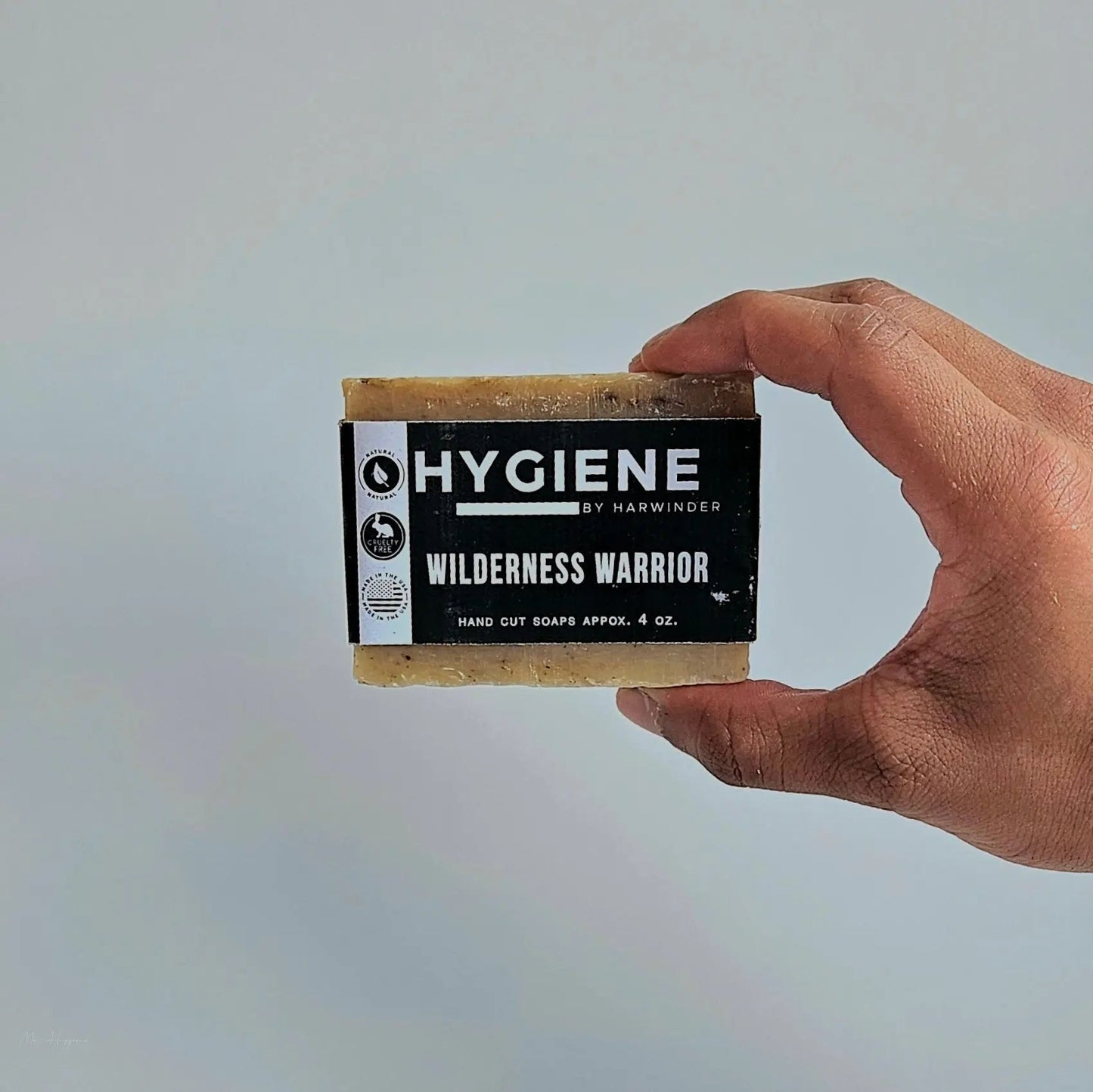 Hand holding Wilderness Warrior Bar Soap against a neutral background.